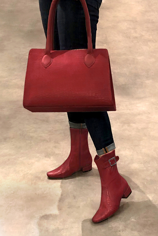 Scarlet red women's ankle boots with buckles on the sides. Round toe. Low block heels. Worn view - Florence KOOIJMAN